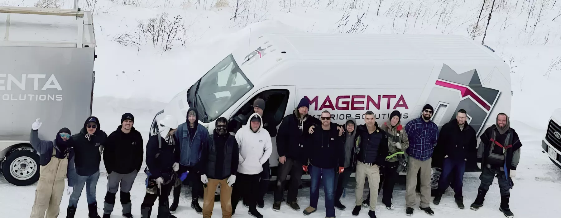Magenta exterior crew standing beside branded work vehicles